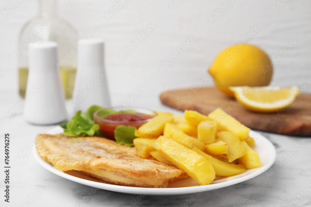 Delicious fish and chips with ketchup and lettuce on light table, closeup Delicious fish and chips with ketchup and lettuce on light table, closeup