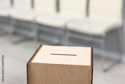 Wooden ballot box on blurred background, closeup. Space for text