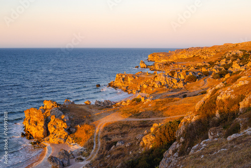 Seascape. Rocky Crimean seashore with a field road in the evening. Travel and tourism.