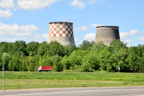large pipes of a thermal power plant against a background of green wood