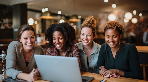 Smiling Friends Gathered Around Laptop in Coffee Shop