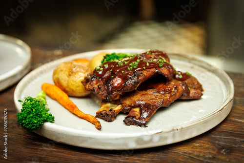 Succulent Grilled Ribs Feast: A succulent serving of grilled ribs, glazed with a rich, glossy sauce and garnished with fresh greens.