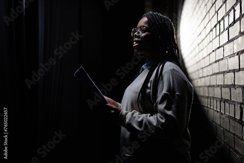 Εκτύπωση καμβά Minimal side view portrait of Black young woman rehearsing on stage in theater w