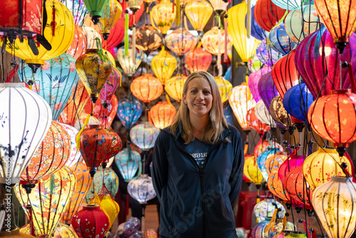 Happy Western tourist among Asian silk lanterns photo