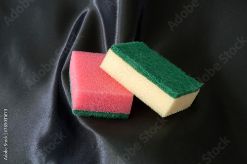 Scouring pads on a black satin background.