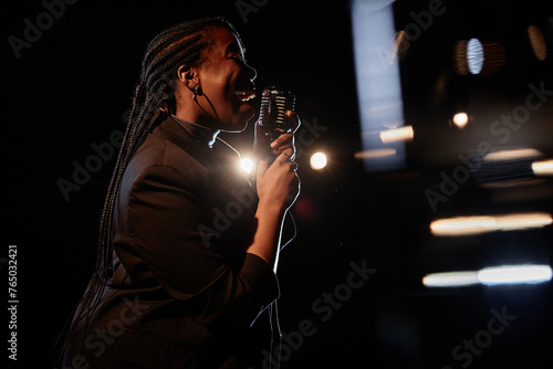 Εκτύπωση καμβά Side view portrait of African American woman singing to microphone while perform