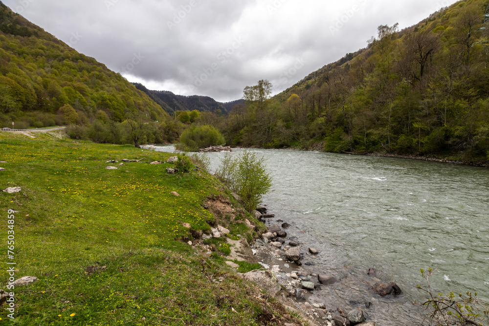 Fototapeta premium Beautiful mountain landscape. Clouds in the sky. Green grass. Snow on mountain peaks. 