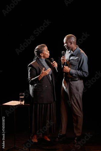 Portrait of two African American people performing on stage together with spotlight