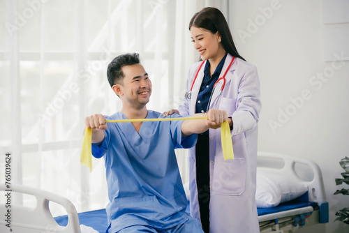 A woman in a white coat is helping a man in a blue shirt stretch