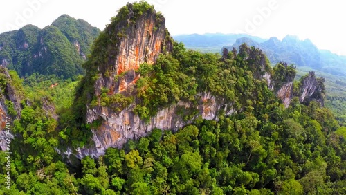 Aerial Shot Of Green Rock Formations At Khao Sok National Park Against Clear Sky, Drone Flying Backwards On Sunny Day - Krabi, Thailand