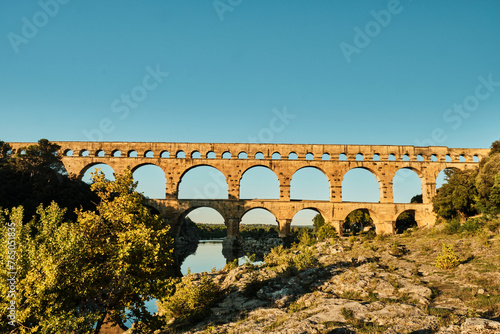 illuminated ancient Roman aqueduct Pont du Gard near Languedoc, France, built as part of the infrastructure for water supply of the roman empire. photo
