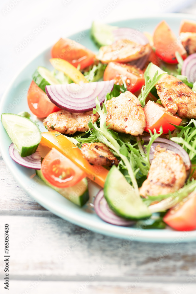 Healthy Salad with Chicken Breast, Cherry Tomatoes, Cucumber, Orange Pepper, Endive and Red Onion. Close up.	