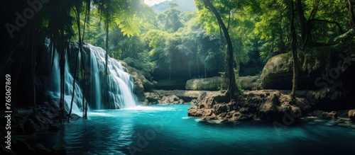 A majestic waterfall flowing in a dense rainforest, the scene brightened by a radiant light shining from above © 2rogan