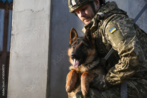 Ukrainian soldier with German shepherd dog outdoors. Space for text © New Africa