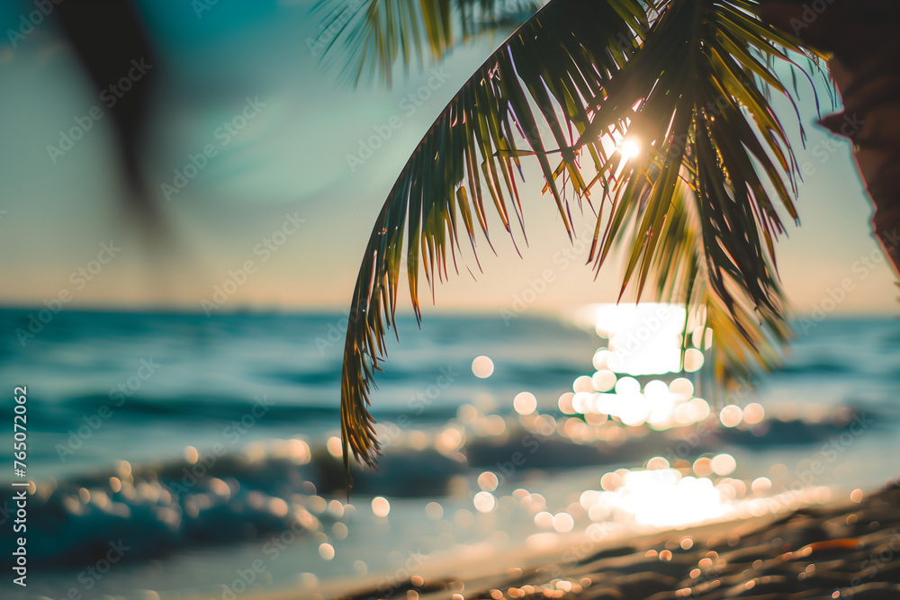 Φωτογραφία paradis sur terre, le soleil se reflétant sur la mer ou l'océan, que l'on aperçoit en arrière-plan flouté à travers les branches d'un palmier sur la plage