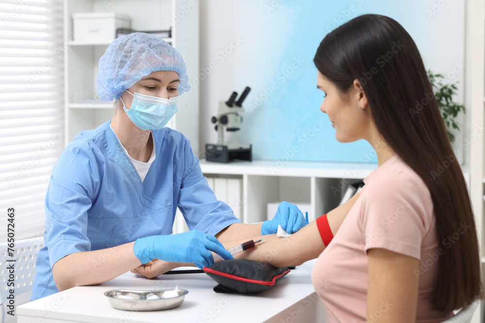 Laboratory testing. Doctor taking blood sample from patient at white table in hospital Laboratory testing. Doctor taking blood sample from patient at white table in hospital