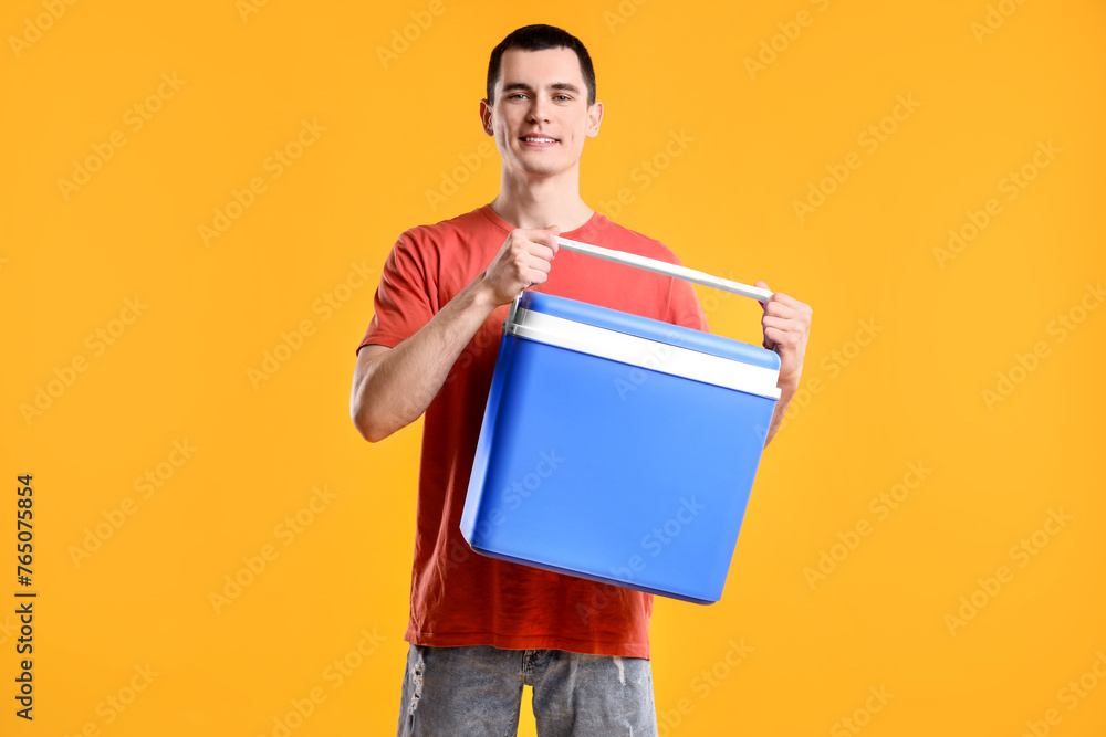Man with blue cool box on orange background Man with blue cool box on orange background