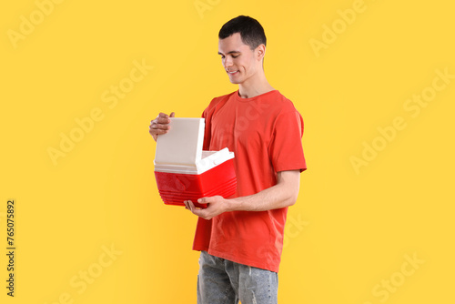 Man with red cool box on orange background