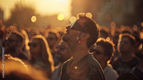 A crowd of people watching the solar eclipse wearing protective glasses photo