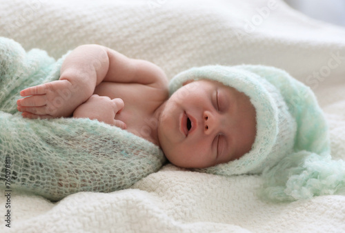 Cute newborn baby in warm hat sleeping on white plaid © New Africa