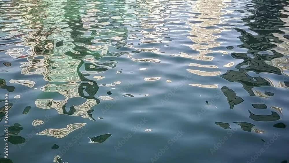 Beautiful closeup slowmotion video of slow flowing natural blue river water surface ripples or waves pattern motion with building reflections. Seamless pure and fresh moving water concept.