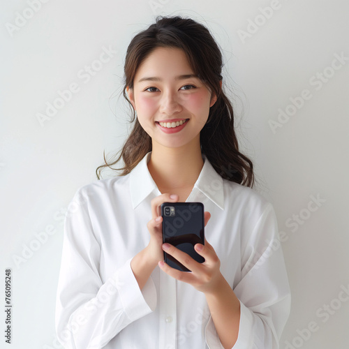 Young Asian Businesswoman in Suit Engaging with Smartphone Technology.
