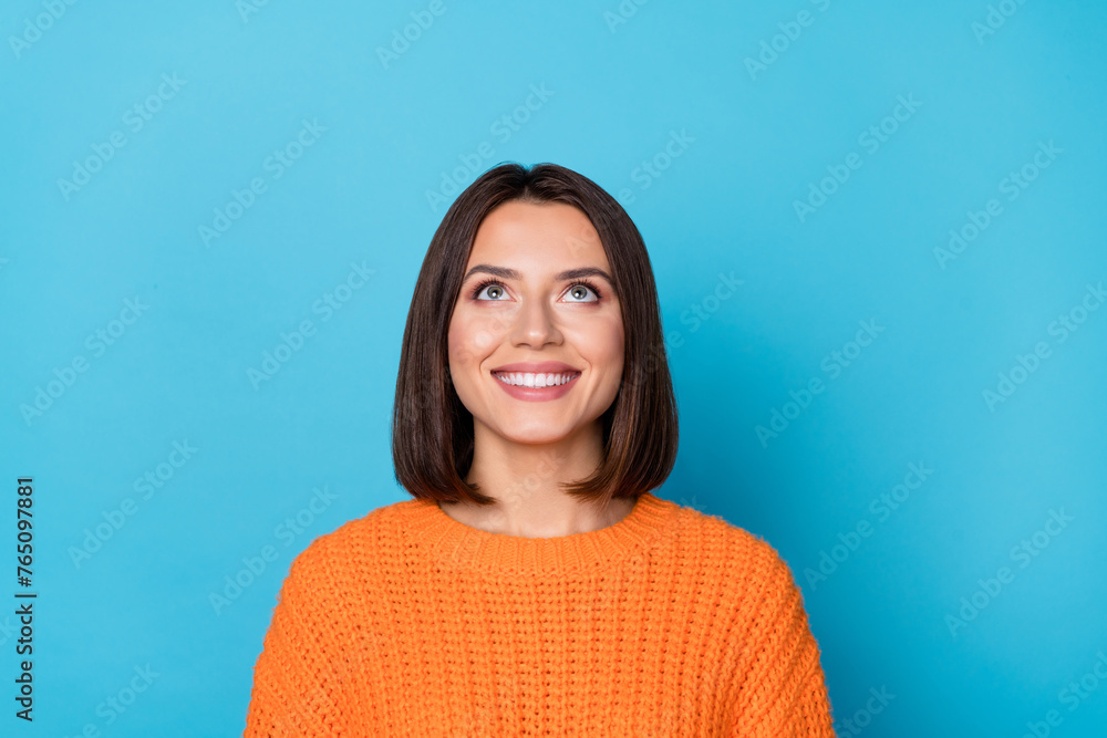 Fototapeta premium Portrait of attractive curious cheerful brown-haired girl looking up copy empty space clue isolated over bright blue color background