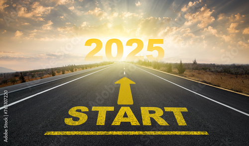 The new year begins. Start written on the empty road and the arrow on the road to the horizon. The number 2025 rising in the sky. New anniversary concept