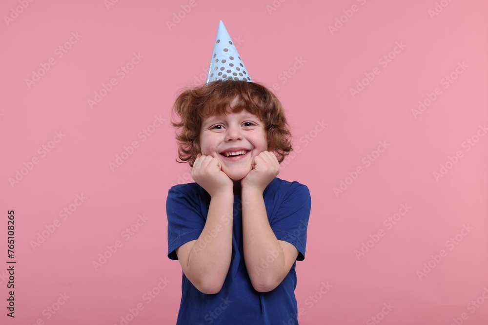 Happy little boy in party hat on pink background Happy little boy in party hat on pink background