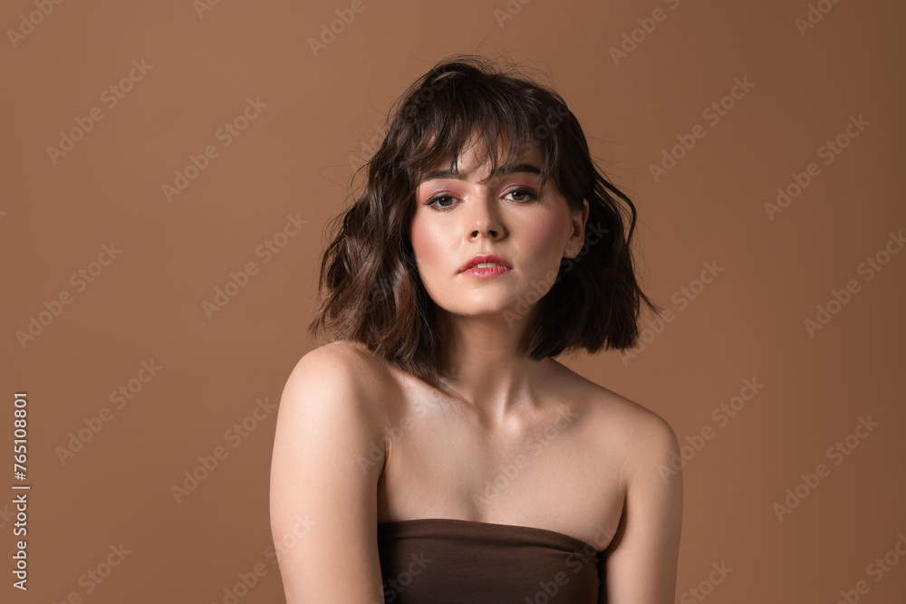 Portrait of beautiful young woman with wavy hairstyle on brown background Portrait of beautiful young woman with wavy hairstyle on brown background