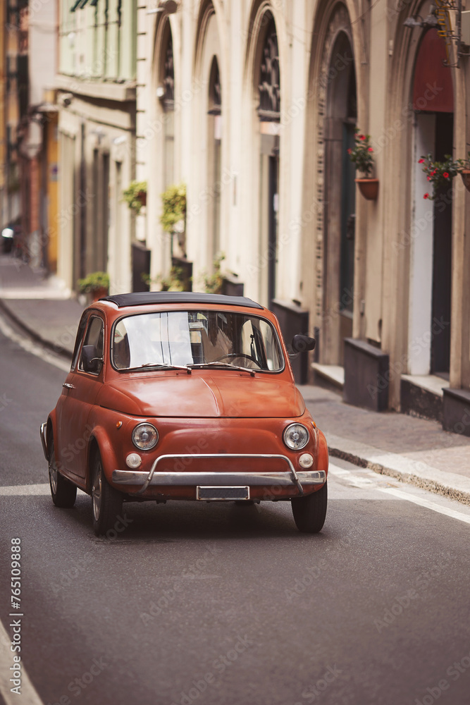 The original tiny car on the streets of Italy. Vintage cars. Old small car  moves down the street.