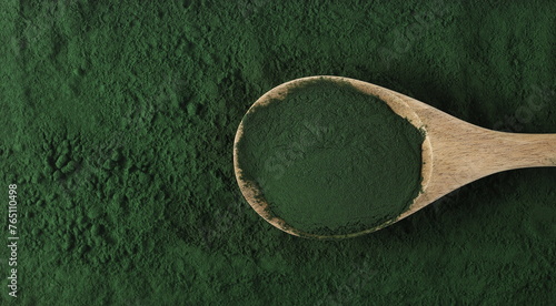 Organic spirulina powder in wooden spoon background and texture, top view © dule964