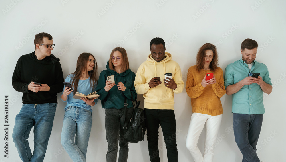 Obraz premium Standing against white background. Group of young people are together