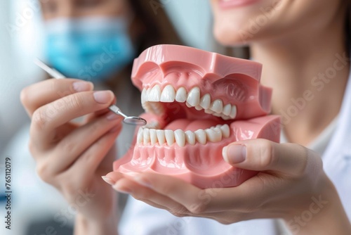 Dentist showing a dental model to a patient, explaining oral health concepts