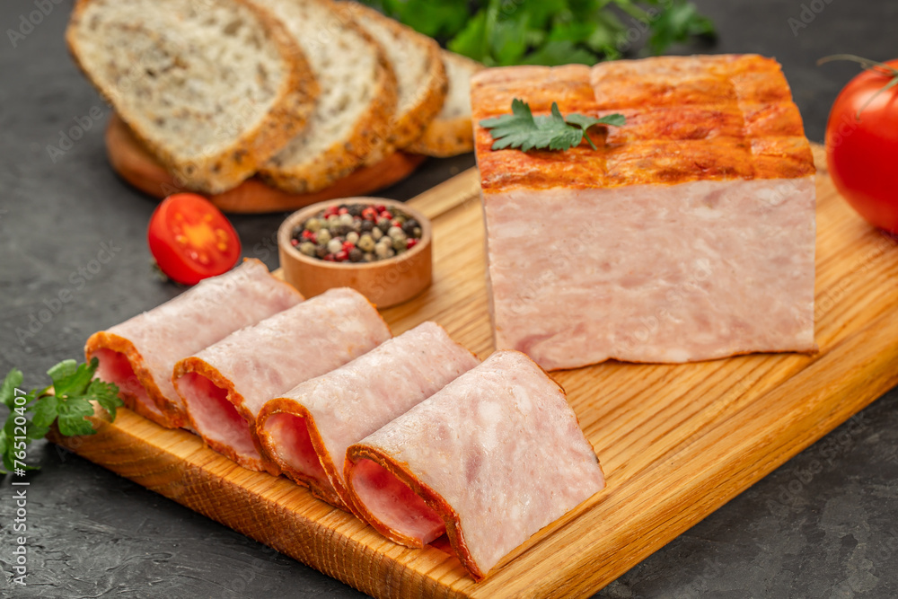 Whole ham covered with aromatic spices with slices on a wooden board, top view. copy space Whole ham covered with aromatic spices with slices on a wooden board, top view. copy space