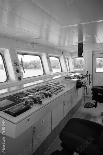 mostek na statku, panel sterowania, fotel kapitana w tle woda. photo