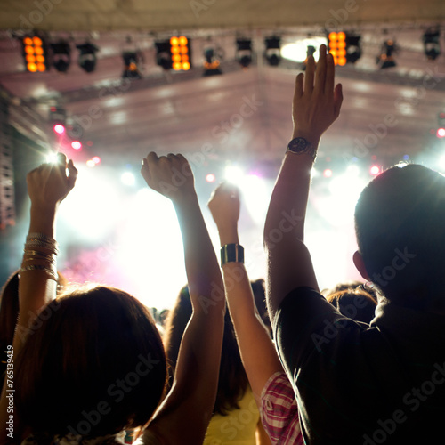 Crowd cheering and watching a band on stage, blurred motion, shallow DOF.