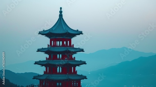 a tall red tower with a clock on the top of it's roof and a mountain in the background.