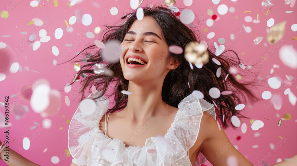 A jubilant woman in a frilly white dress is amidst a shower of colorful confetti.
