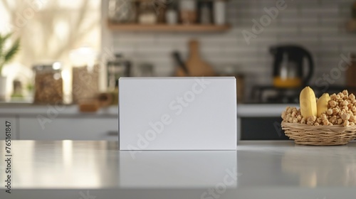 White box on the kitchen counter. There is a basket of lemons and nuts next to it. The background is blurred. photo