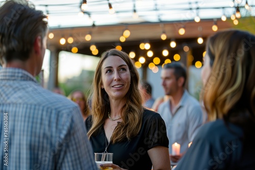A woman stands next to a man holding a glass of beer at a social gathering like a happy hour event photo