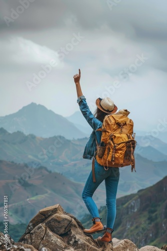 A woman standing on a rock with a backpack. Ideal for outdoor adventure concepts