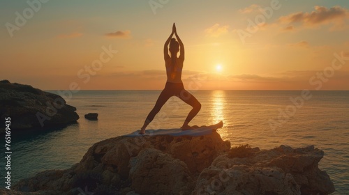 Person doing yoga on a rock by the ocean. Suitable for wellness and relaxation concepts
