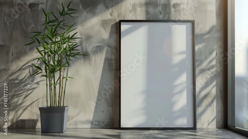 Potted bamboo plant casting a delicate shadow on a blank photo frame
