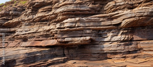 A person standing on a close-up rock formation with visible sedimentary layers