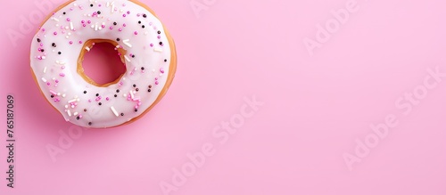 Donut with colorful sprinkles on pink table
