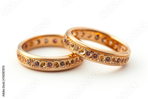 Elegant and Timeless: Two Exquisite Gold Wedding Rings Adorned with Stones on a White Background