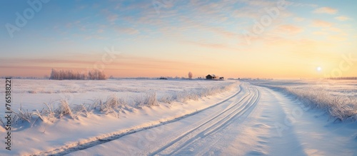 Country road in snowy field at sunset