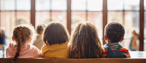 Three kids on bench by window & diverse students hugging at school gym photo