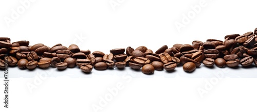 Coffee beans arranged in a pile on a white surface